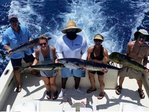 group showing their catch on a deep sea fishing charter
