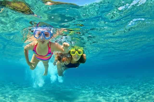 Mother and daughter snorkeling underwater
