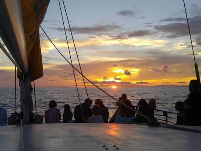 group watching sunset on dolphin cruise