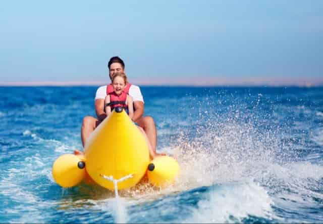 Father and son riding on a banana boat