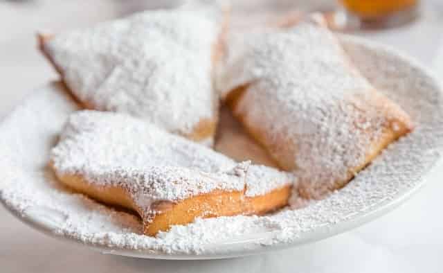 Beignets on a plate with powdered sugar