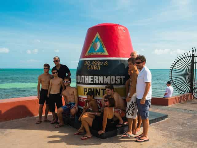 Tourist-posing-with-Southernmost-Point-landmark-in-Key-West-Florida