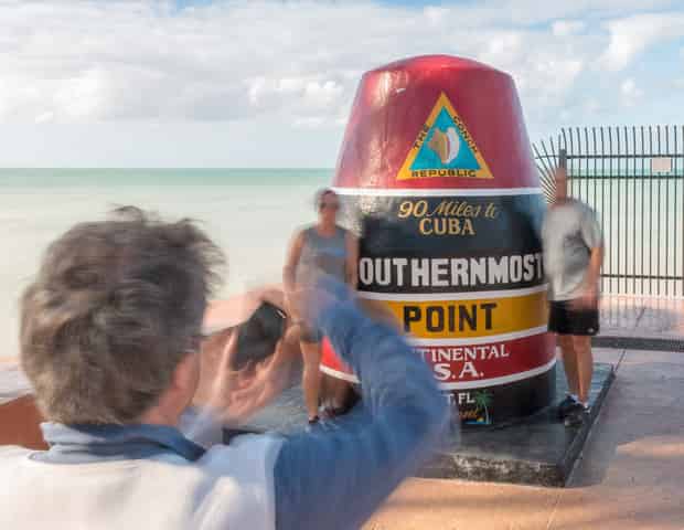 Tourist-snapping-photo-at-Southernmost-Point-landmark-in-Key-West