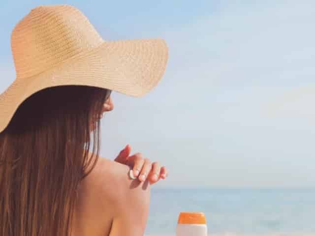 woman applying sunscreen in Pensacola Beach, FL
