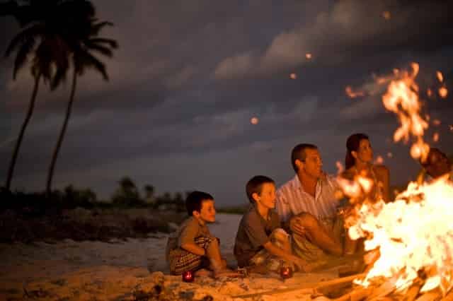 Family beside bonfire on a beach
