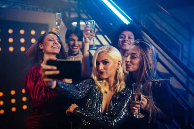 Friends taking selfies at a nightclub