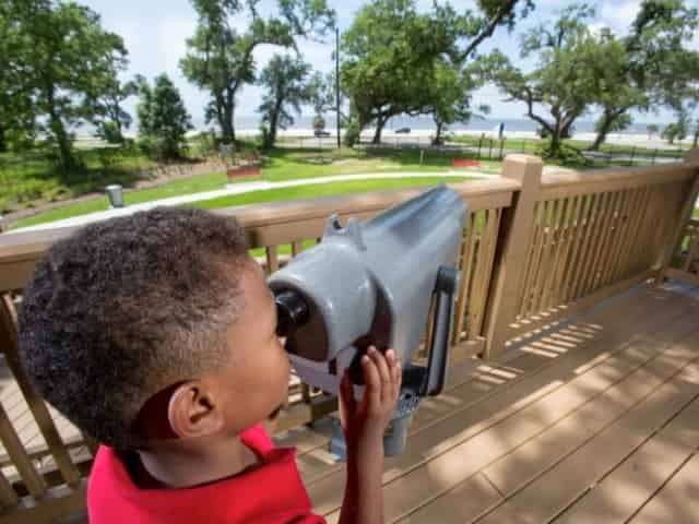 child with a telescope at lynn meadows discovery center