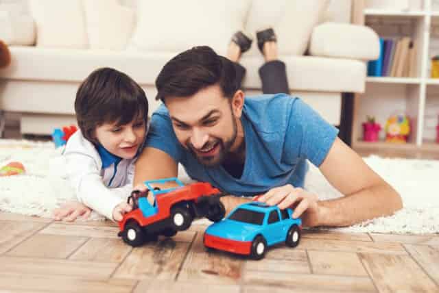 father and son playing with toy cars