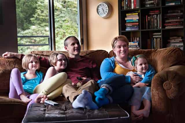 parents and children watching tv together during a staycation