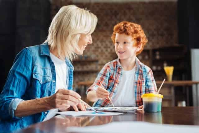 mother and son painting pictures in the kitchen at home