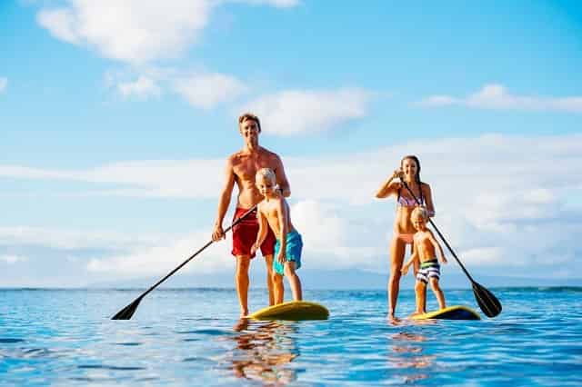 Family paddleboarding through the water